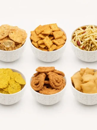 Diwali Indian Savoury Snacks Festive Collection Featuring Six Varieties Of Traditional Golden-Brown Indian Namkeen Served In White Bowls.